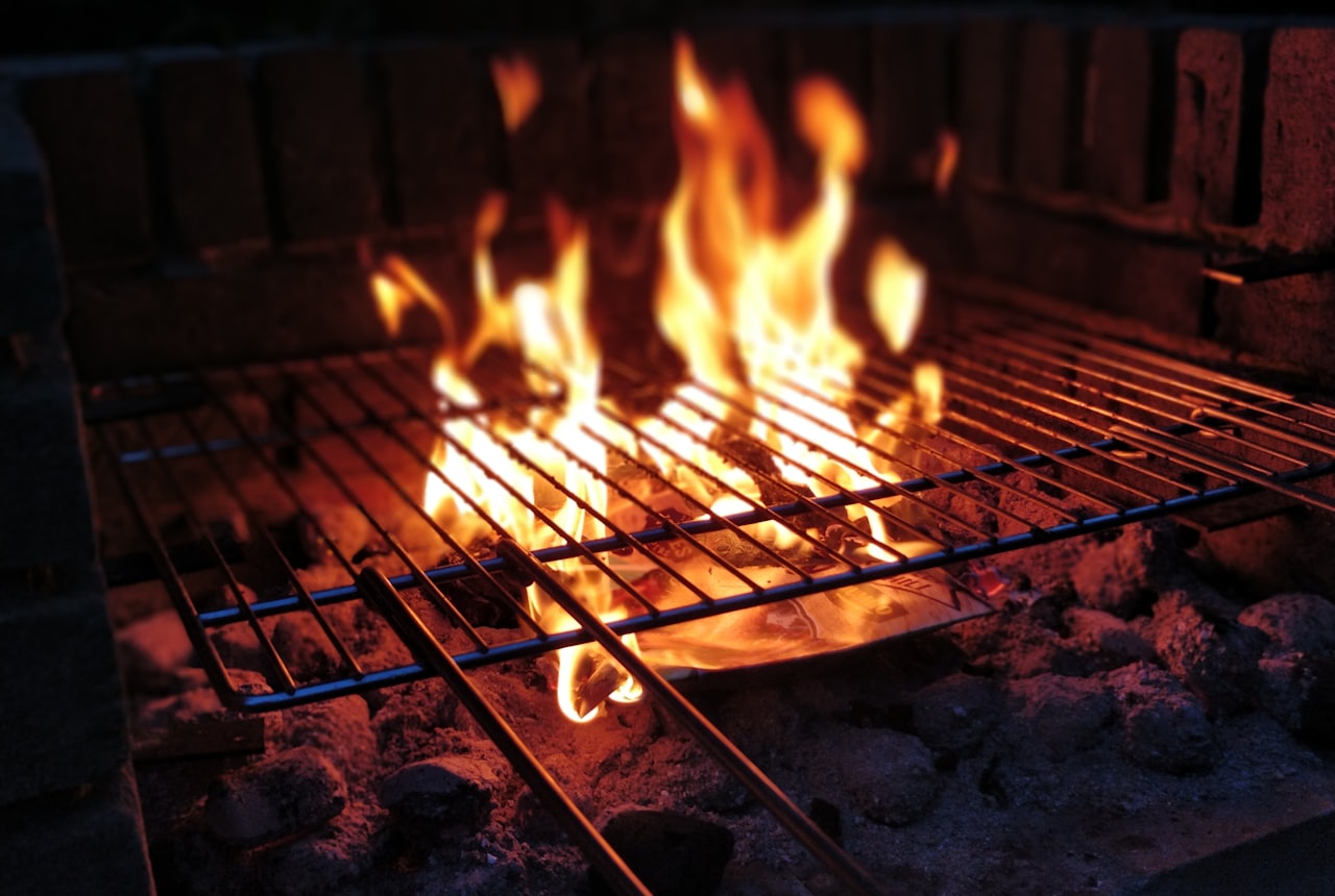 Meat grilling slowly over glowing wood coals on a parrilla