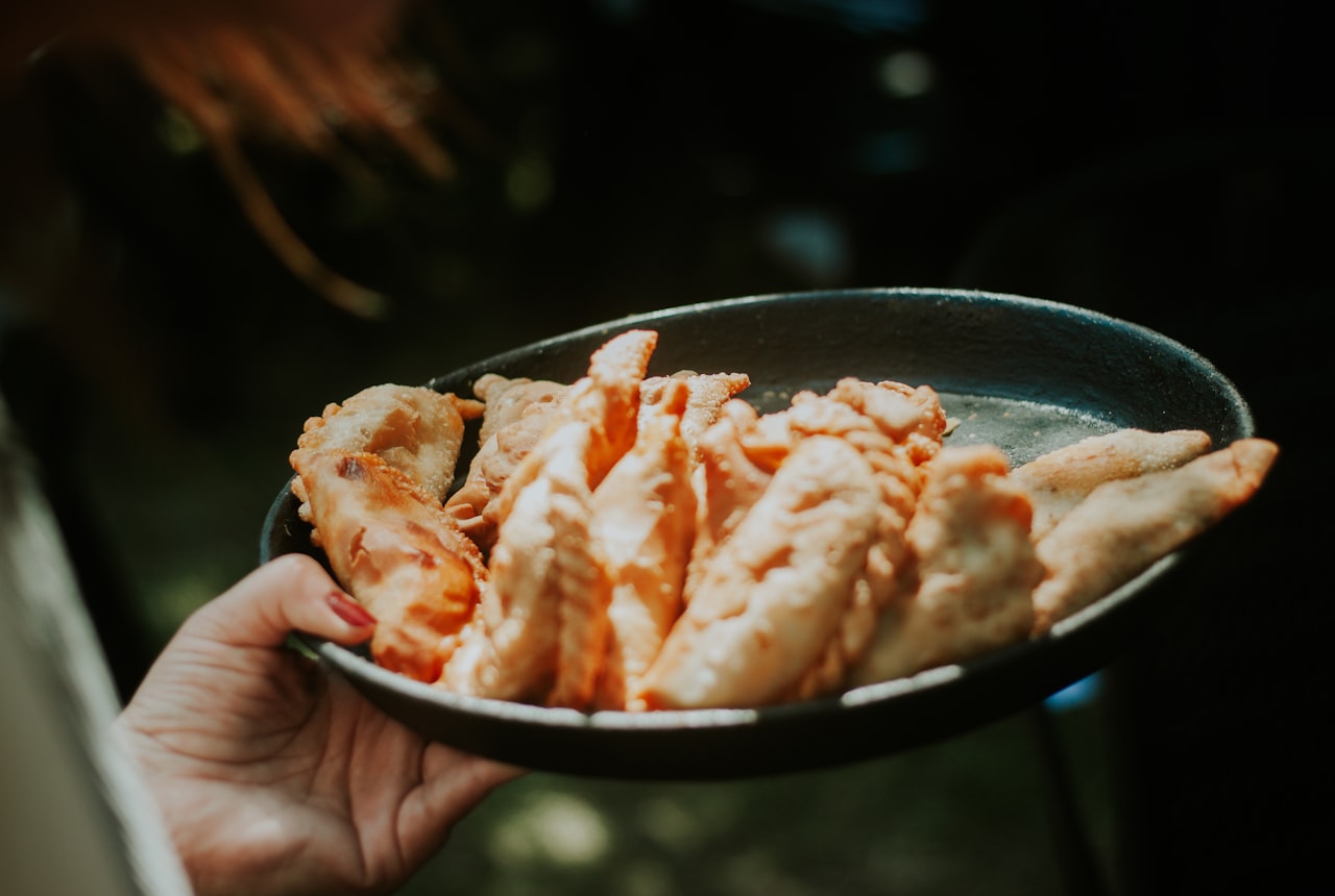 Golden hand-folded Argentine empanadas on a plate