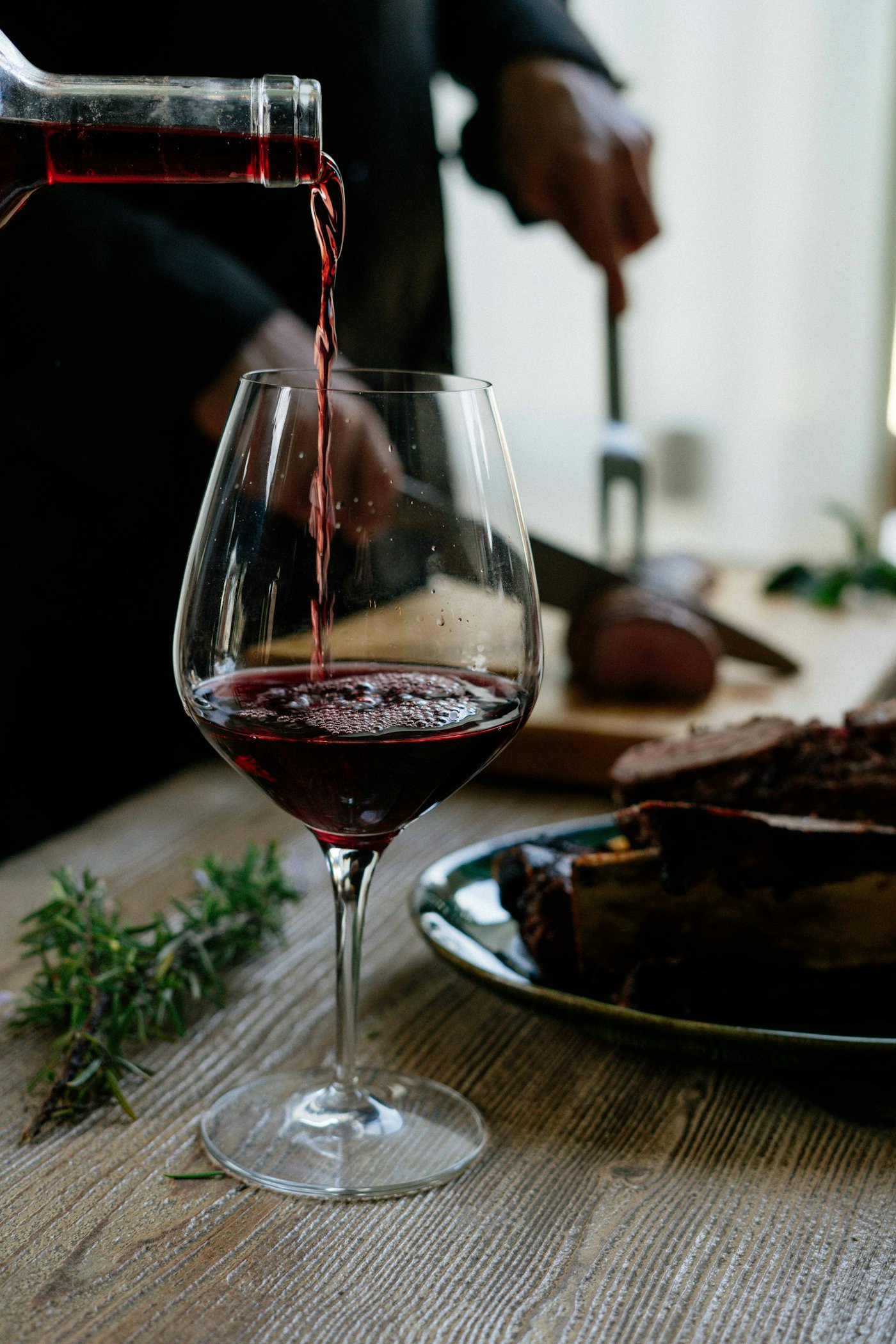 Red wine being poured at a vineyard table