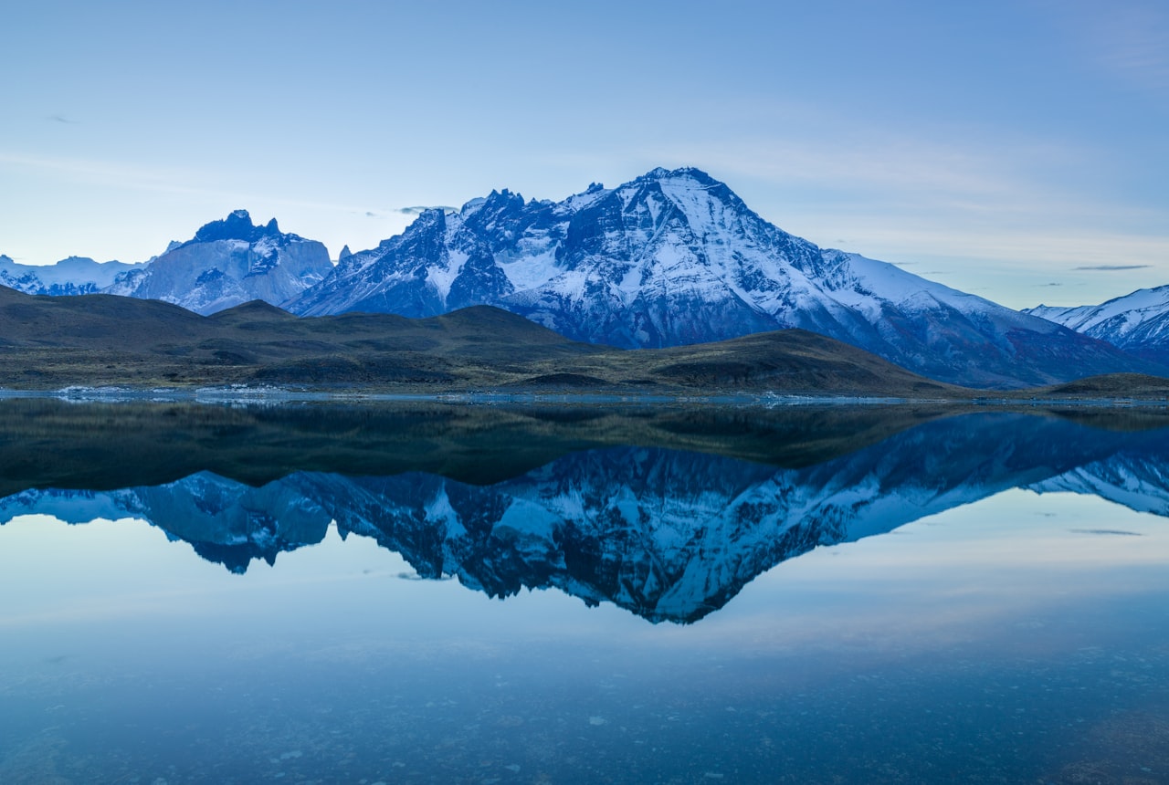 A still Patagonian lake ringed by mountains, near the Río Negro wine valleys