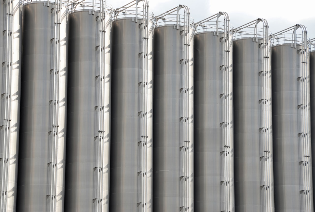 Rows of gleaming stainless steel fermentation tanks in a modern winery