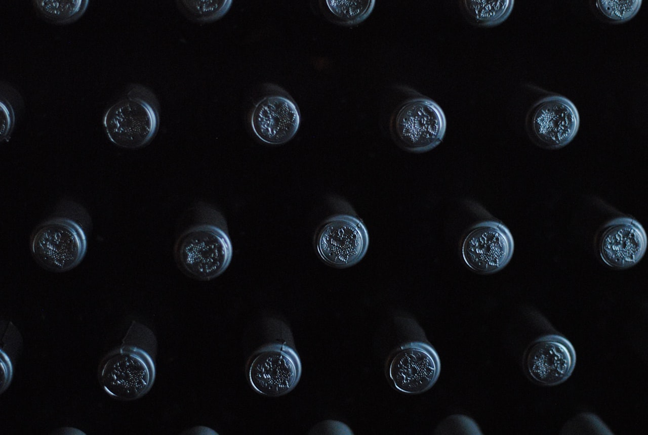 Several open wine bottles lined up on a counter
