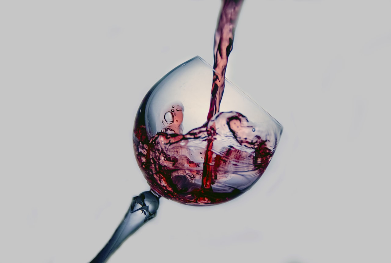 A person swirling and smelling a glass of red wine