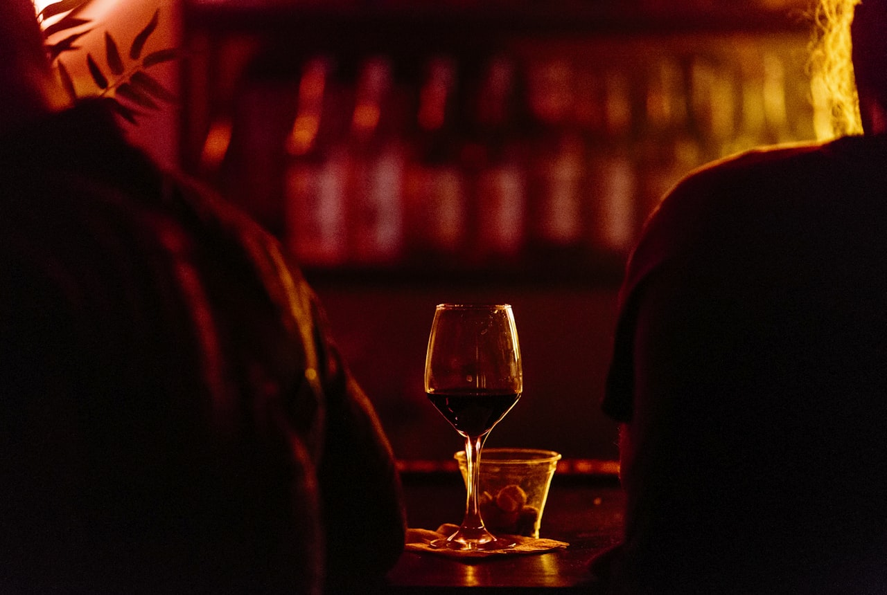 A glass of Malbec resting on a cellar shelf