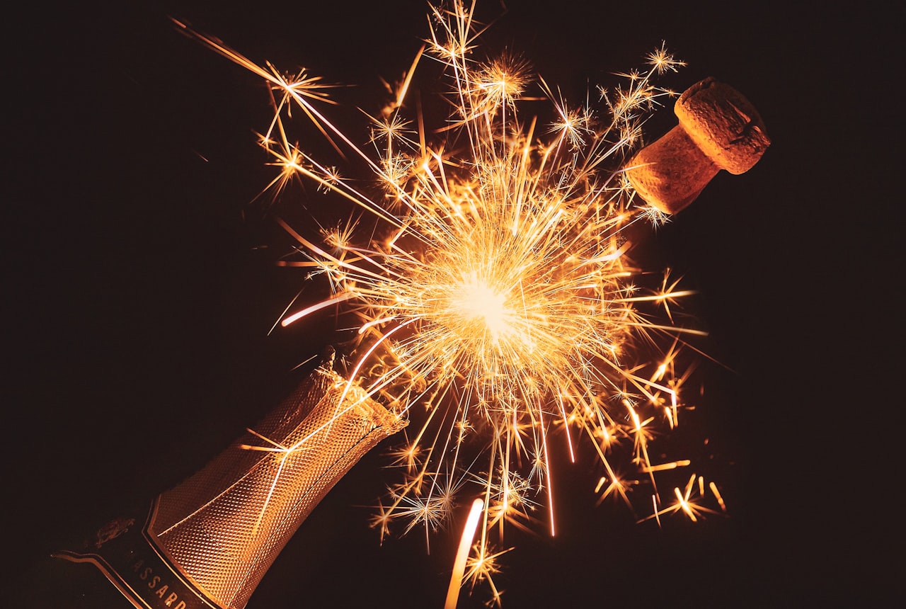 A Champagne bottle held by the punt with the index finger inside it, the classic sommelier pouring grip