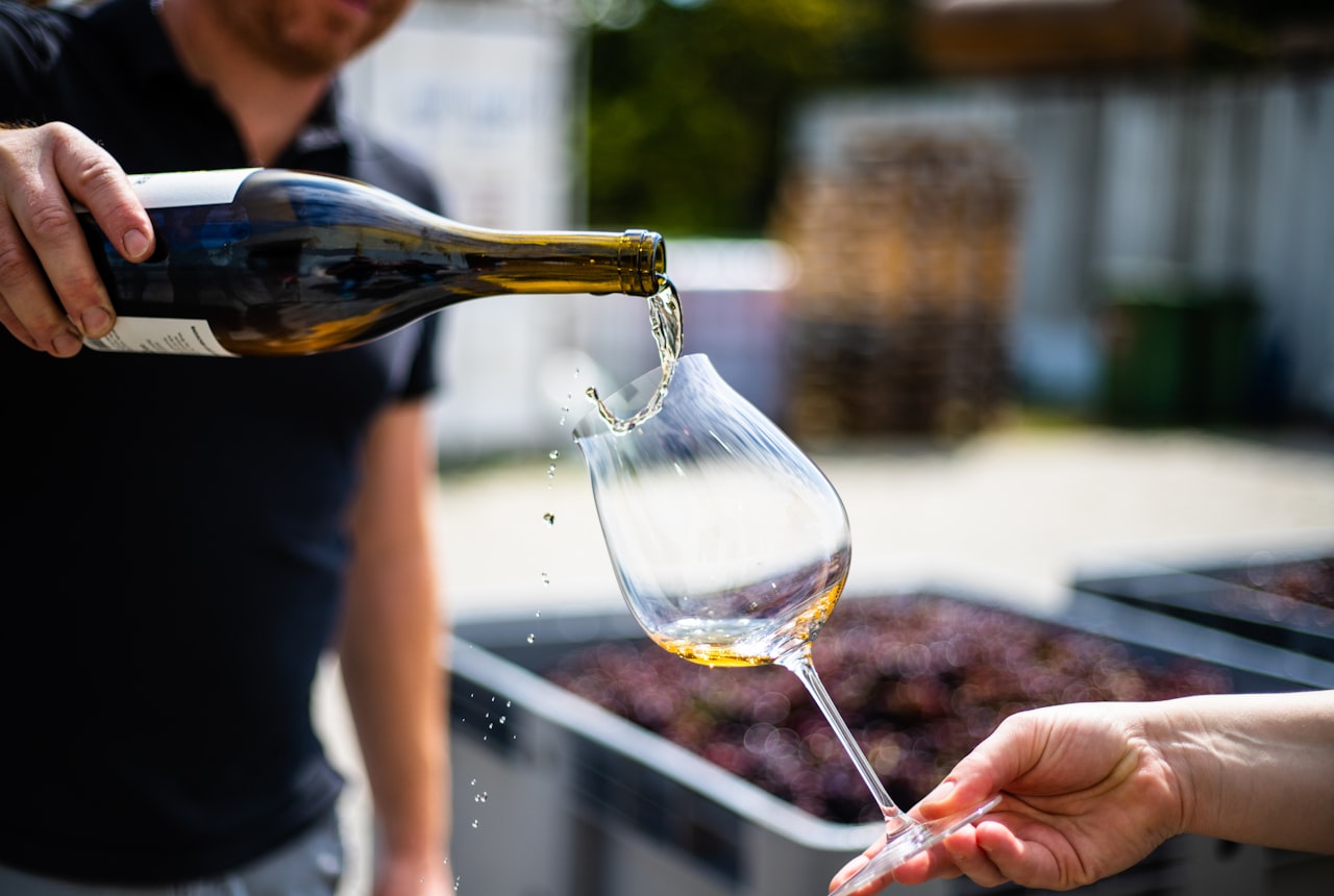 An old wine bottle being decanted with a lit candle underneath the neck, sediment visible
