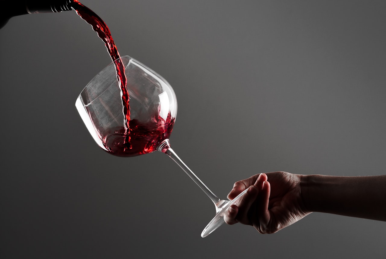 Someone double-decanting wine — pouring from a decanter back into a bottle, motion captured