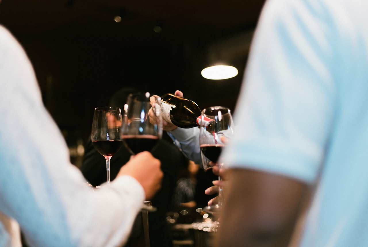 A sommelier's table with a young Malbec being decanted and glasses ready in warm wine cellar light