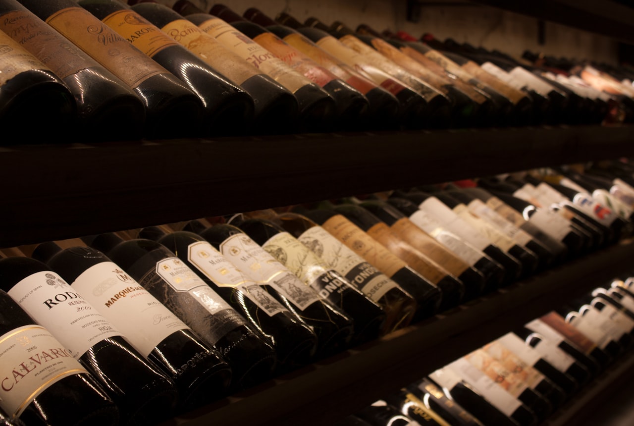 Extreme close-up of a wine bottle label at an angle, warm side-light catching the paper texture