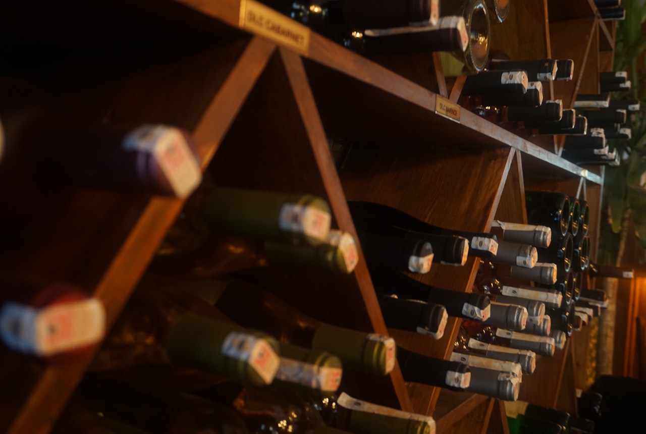 A thermometer placed on a wooden wine rack with several bottles, soft warm light