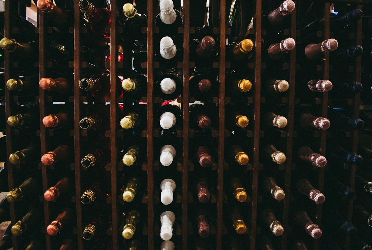 Dark closed cabinet with wine bottles barely visible inside, single soft light source