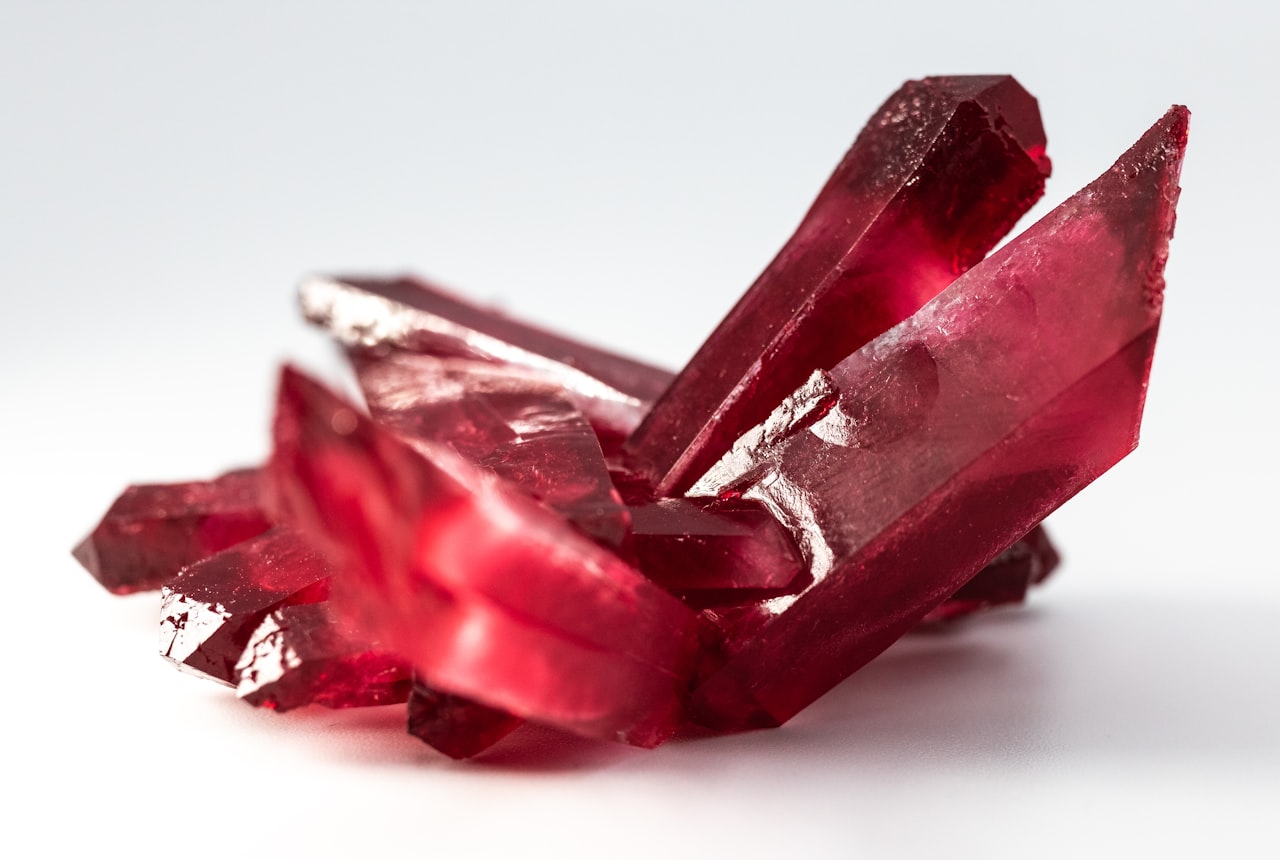 A single Burgundy-shaped glass with translucent ruby Pinot Noir, warm bokeh background
