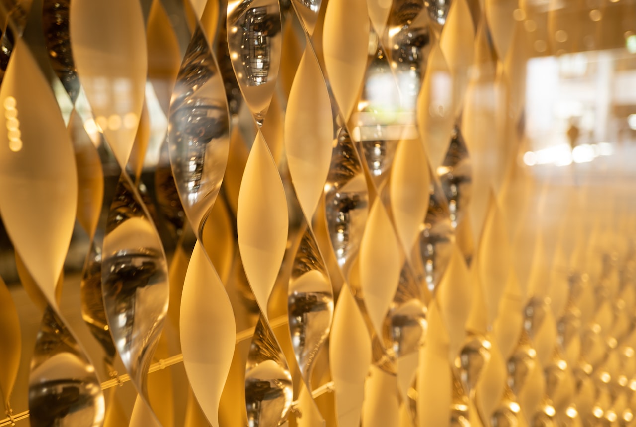 A tulip-shaped sparkling glass with golden bubbles rising, warm candlelight backdrop