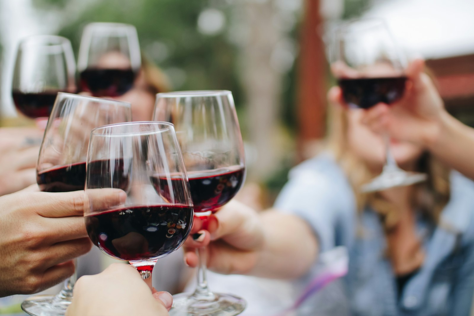 Red wine being poured into a glass at a table
