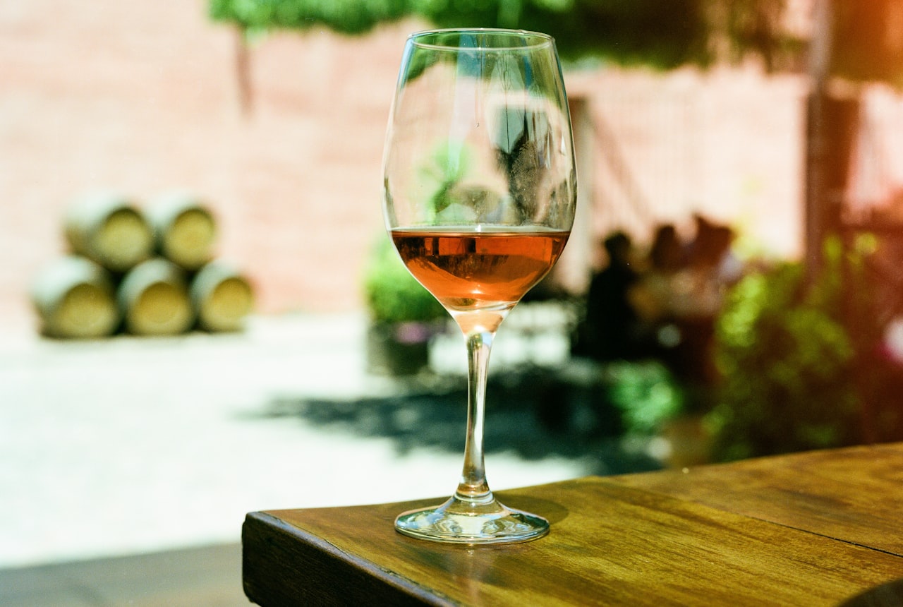 A glass of dark red Malbec with grapes beside it