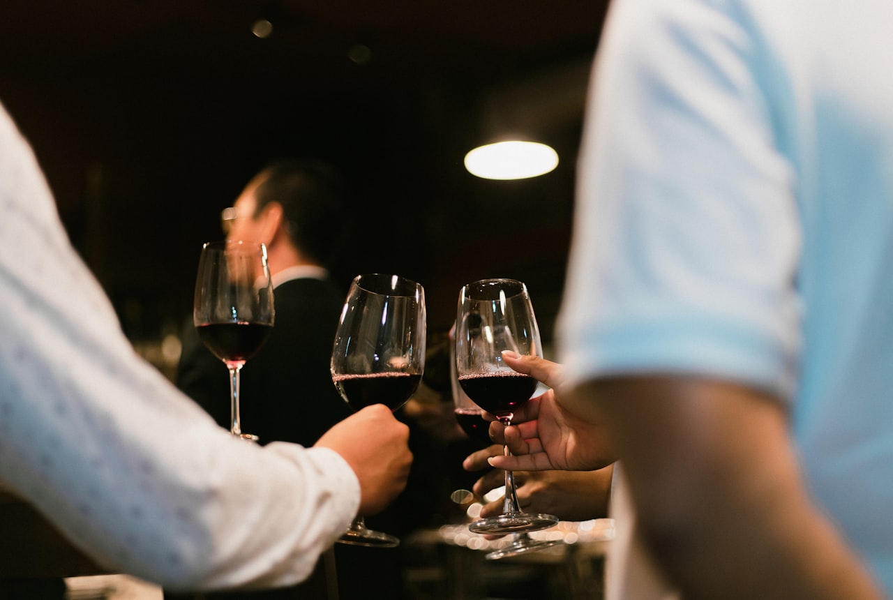 A glass of deep purple-red Syrah being poured